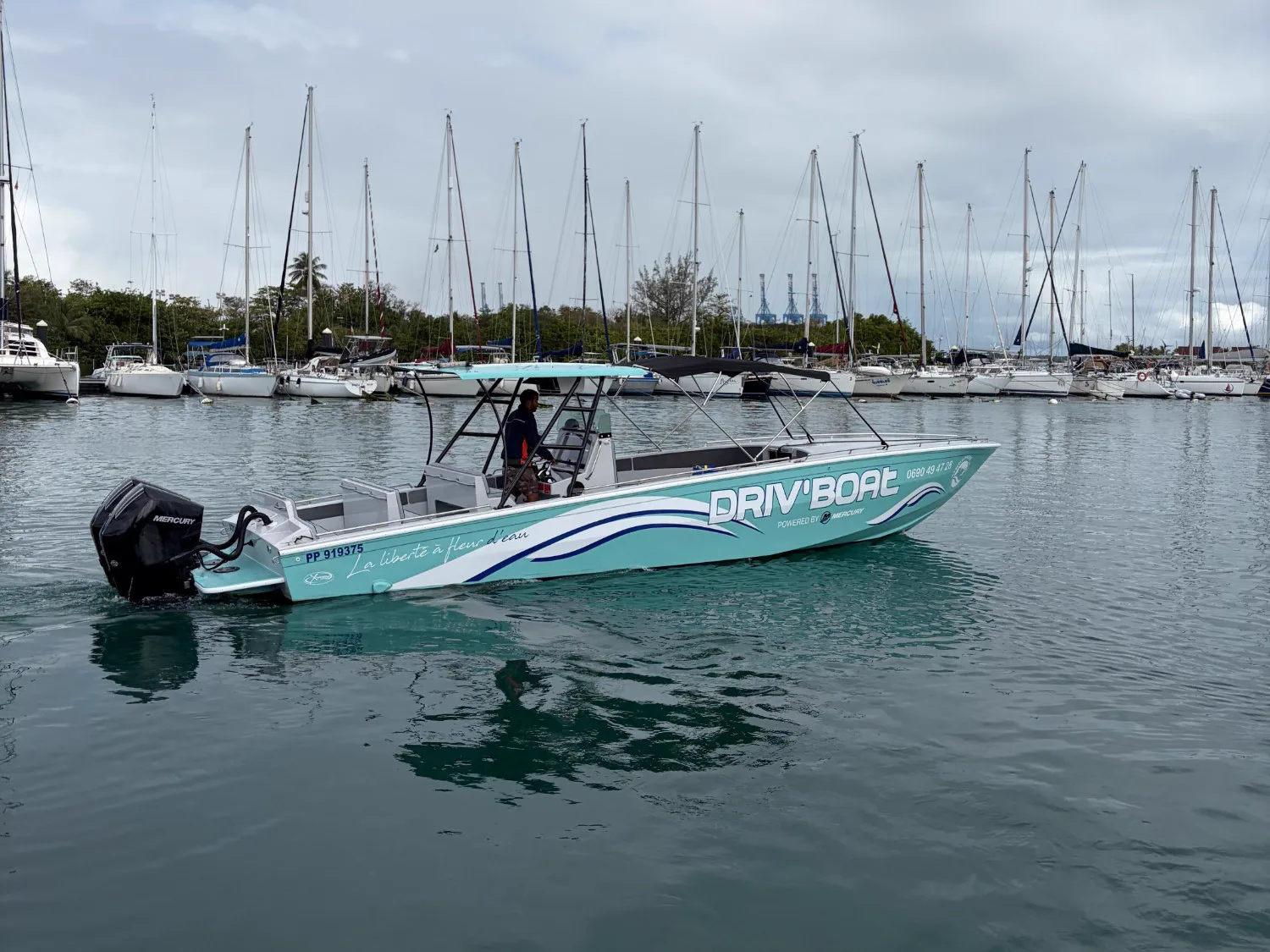 Le bateau Atom de Driv'Boat naviguant dans la marina, en Guadeloupe